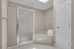 Master King suite private bathroom featuring a walk in shower and soaking tub